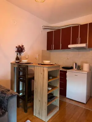 a kitchen with a wooden island in the middle at Studio29 2 in Ruma