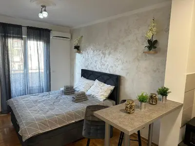 a small bedroom with a bed and a table at xenija in Belgrade
