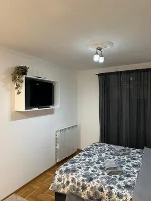 a bedroom with a bed and a tv on the wall at xenija in Belgrade