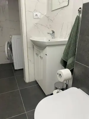 a white bathroom with a sink and a toilet at M&O Belgrade in Belgrade
