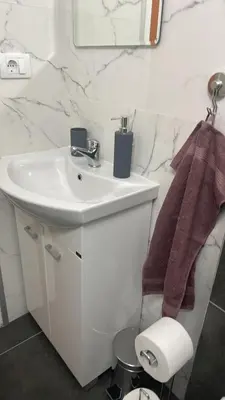 a white bathroom with a sink and a mirror at M&O Belgrade in Belgrade