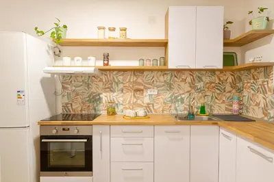 a kitchen with white cabinets and a white refrigerator at NaFiJa Apartman in Smederevo