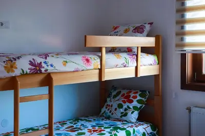 two bunk beds in a room with a chair at NaFiJa Apartman in Smederevo