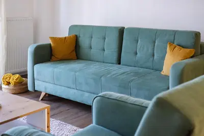 a blue couch in a living room with yellow pillows at NaFiJa Apartman in Smederevo