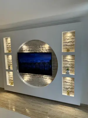 a wall with a television in a room with two shelves at Apartman City Zeleznik in Belgrade