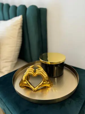 a gold plate with a heart on a table at Apartman City Zeleznik in Belgrade