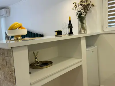 a kitchen with a counter with a sink and wine bottles at Apartman City Zeleznik in Belgrade