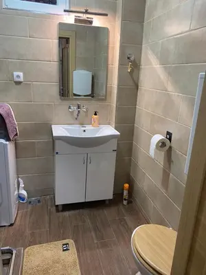 a bathroom with a sink and a mirror and a toilet at Lukas Apartment in Belgrade