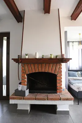 a living room with a brick fireplace with two vases on it at View Point House in Smederevo