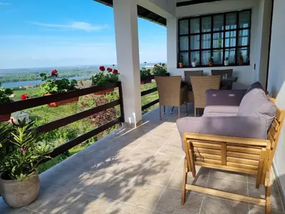 a patio with a couch and a table and chairs at View Point House in Smederevo