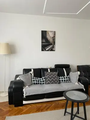 a living room with a black couch and a table at Apartment Sofia in Belgrade