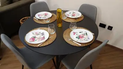 a black table with plates and wine glasses on it at Eden Spa Apartman in Arandjelovac
