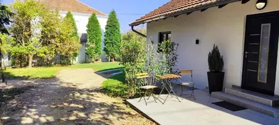 a patio with a table and chairs next to a house at Eden Spa Apartman in Arandjelovac
