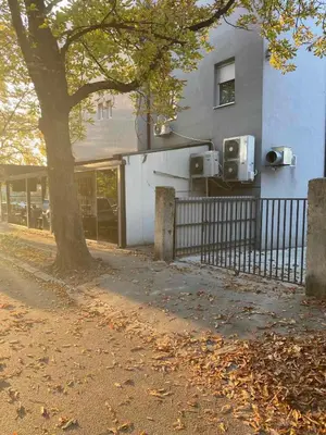 a building with a tree next to a fence at Top Central 6 Apartments in Belgrade