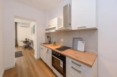a kitchen with white cabinets and a wooden counter top at Top Central 6 Apartments in Belgrade