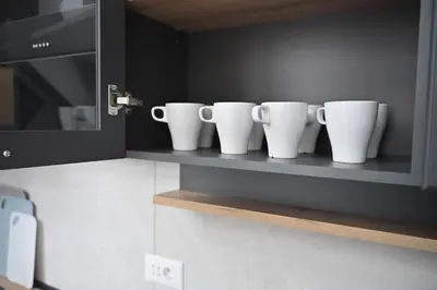 four white cups sitting on a shelf in a kitchen at Top Central 6 Apartments in Belgrade