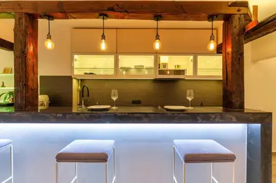 a bar in a kitchen with two stools at City Centre Rooftop Knez Mihailova Apartment in Belgrade