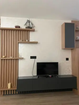 a living room with a tv on a black table at Apartman Silver Bg in Kneževac