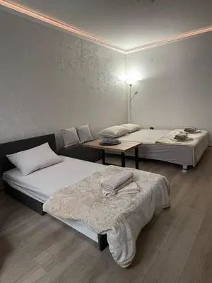 a room with two beds and a table in it at Apartman Silver Bg in Kneževac