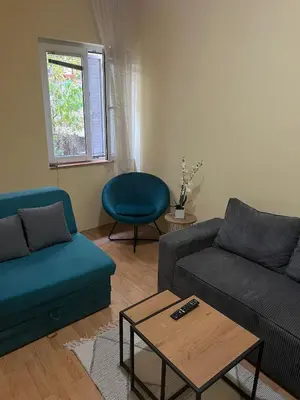 a living room with two couches and a table at TripleA Sr apartments in Belgrade