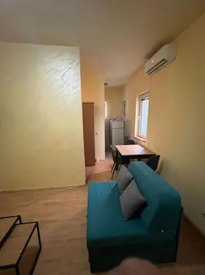 a living room with a blue couch and a table at TripleA Sr apartments in Belgrade
