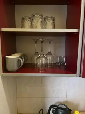 a shelf with wine glasses and cups on it at TripleA Sr apartments in Belgrade