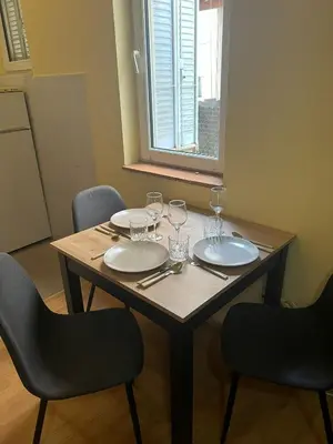 a wooden table with plates and wine glasses on it at TripleA Sr apartments in Belgrade