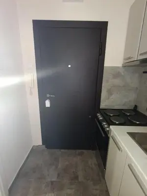 a black door in a kitchen with a stove at Vist 3 apartment in Belgrade