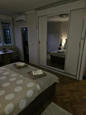 a bedroom with a bed and a large mirror at Nadja City Center in Belgrade