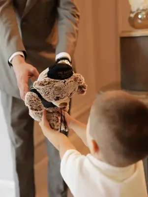 a young child holding a teddy bear with a man at The Bristol Belgrade in Belgrade