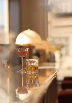 a glass of wine on a table with a drink at The Bristol Belgrade in Belgrade