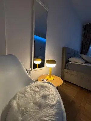 a living room with a bed and a table with a lamp at Lux Vracar by Magenta in Belgrade