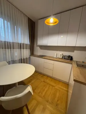 a kitchen with a table and a table and a chair at Lux Vracar by Magenta in Belgrade