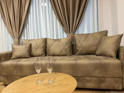 a couch with two wine glasses on a table at Lux Vracar by Magenta in Belgrade