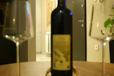 a bottle of wine sitting on a table next to a glass at R&B apartments in Belgrade