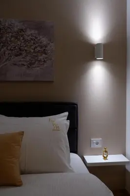 a bedroom with a bed with a light on the wall at R&B apartments in Belgrade