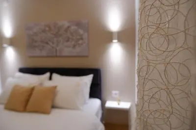 a bedroom with a bed and a tree painting on the wall at R&B apartments in Belgrade