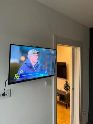 a flat screen tv on a wall in a living room at R&B apartments in Belgrade
