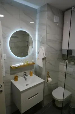a bathroom with a sink and a toilet and a mirror at R&B apartments in Belgrade