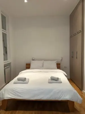 a bedroom with a large white bed with two towels on it at City Centre Retreat Palmoticeva Studio in Belgrade
