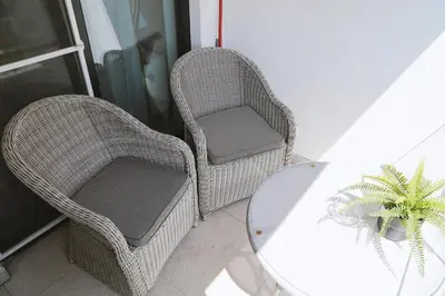 two wicker chairs and a table with a glass table at SARA Lux A Blok in Belgrade