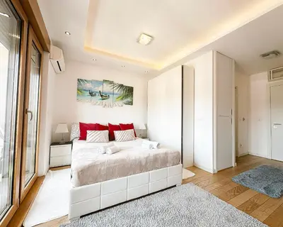 a bedroom with a large bed with red pillows at SARA Lux A Blok in Belgrade