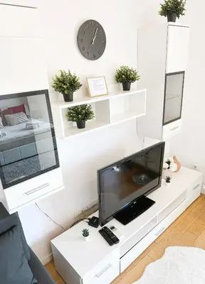 a living room with a tv on a white table at SARA Lux A Blok in Belgrade