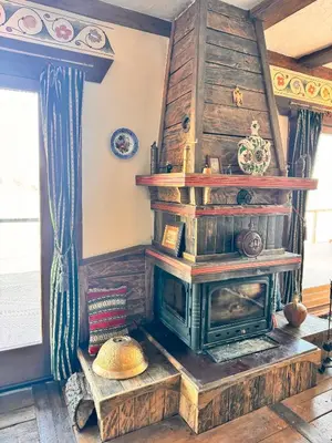 a fireplace in a living room with wooden walls at Guesthouse Perunov Konak in Belgrade