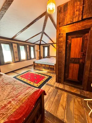 a bedroom with two beds in a room with wooden walls at Guesthouse Perunov Konak in Belgrade