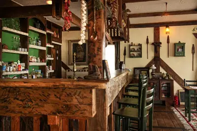 a bar with a wooden counter and some chairs at Guesthouse Perunov Konak in Belgrade
