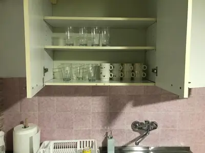 a kitchen with a shelf with glasses on it at Family escape apartment free parking in Belgrade