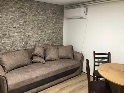 a living room with a couch and a brick wall at Family escape apartment free parking in Belgrade