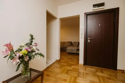 a living room with a vase of flowers on a table at Bright, Newly Renovated Condo Near Danube River in Belgrade