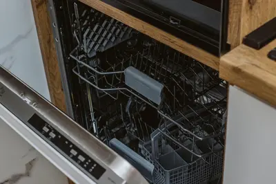 an open dishwasher with a dish rack in it at Bright, Newly Renovated Condo Near Danube River in Belgrade